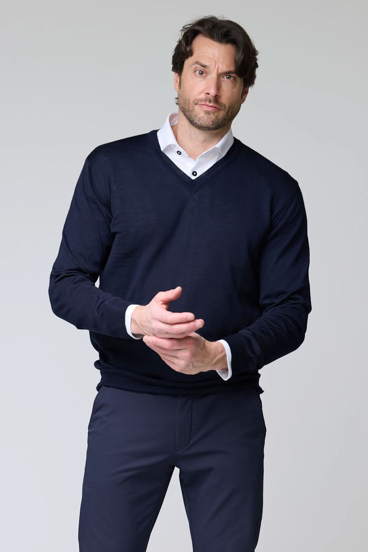 Chandail col en V en laine mérinos pour homme, élégant et raffiné, porté sur une chemise blanche. Disponible en noir et en marine.