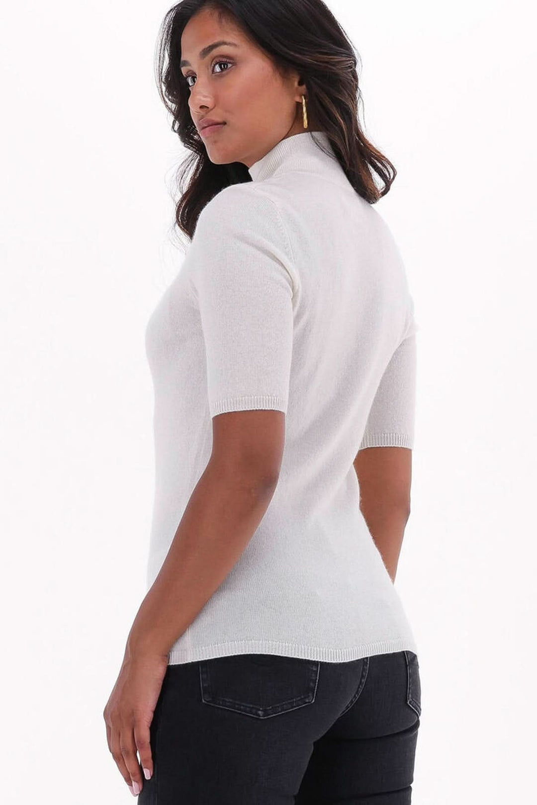 Femme portant un chandail col montant manches courtes — maille fine, en maille douce, avec jean foncé, style moderne.