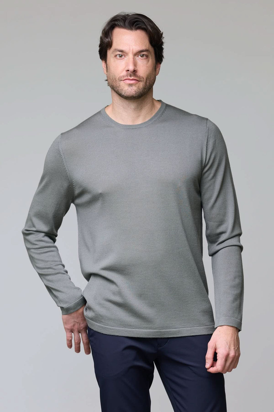 Homme portant un chandail col rond en tricot fin gris avec manches longues et coupe ajustée.