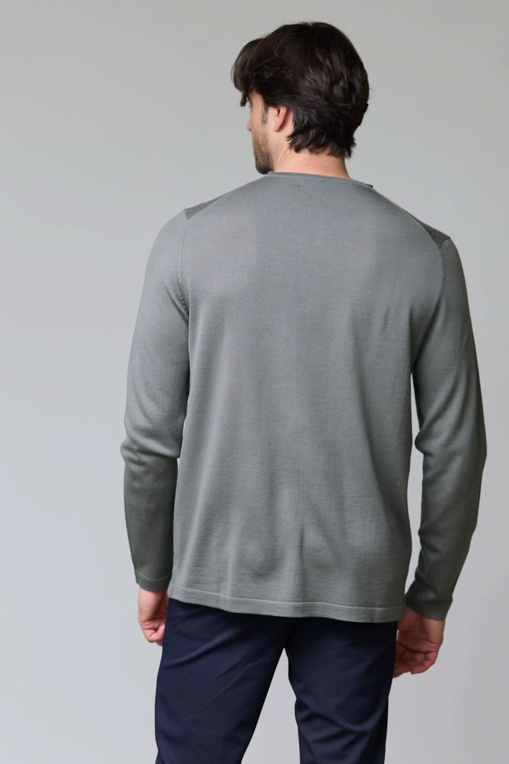 Homme portant un chandail col rond en tricot fin gris de dos, texture douce et coupe ajustée. Décris moi le produit en français.
