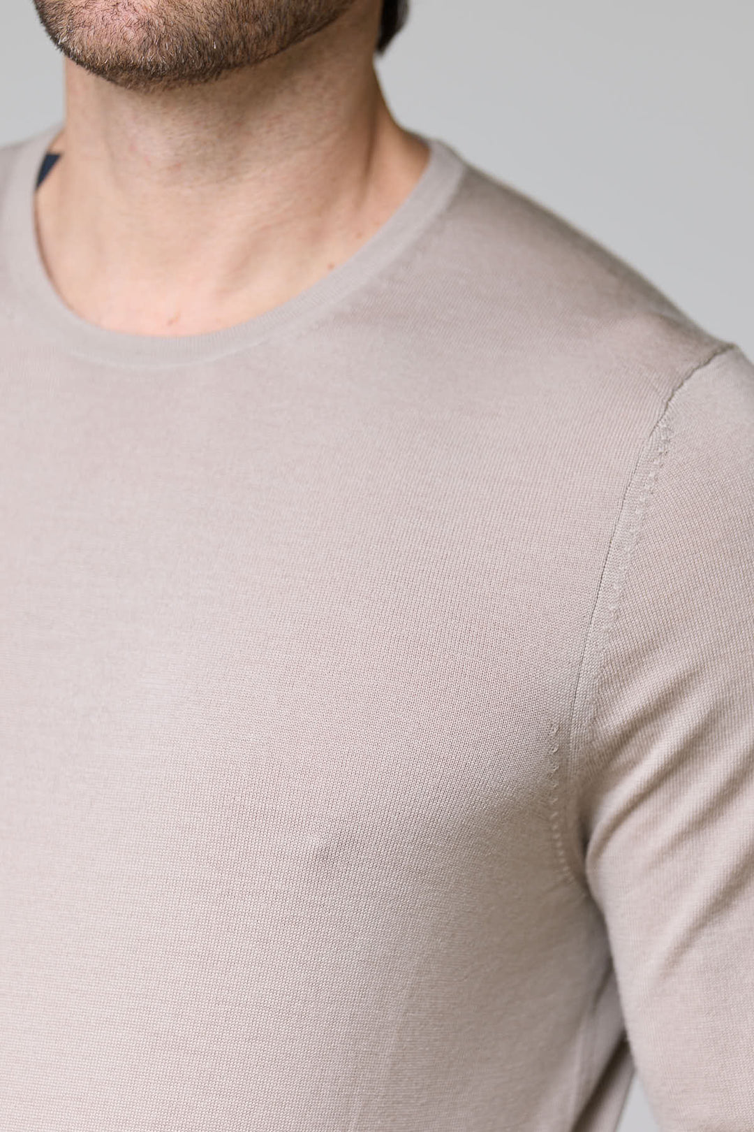 Homme portant un chandail col rond en tricot fin, texture douce et ajustée, idéal pour un look élégant et confortable.