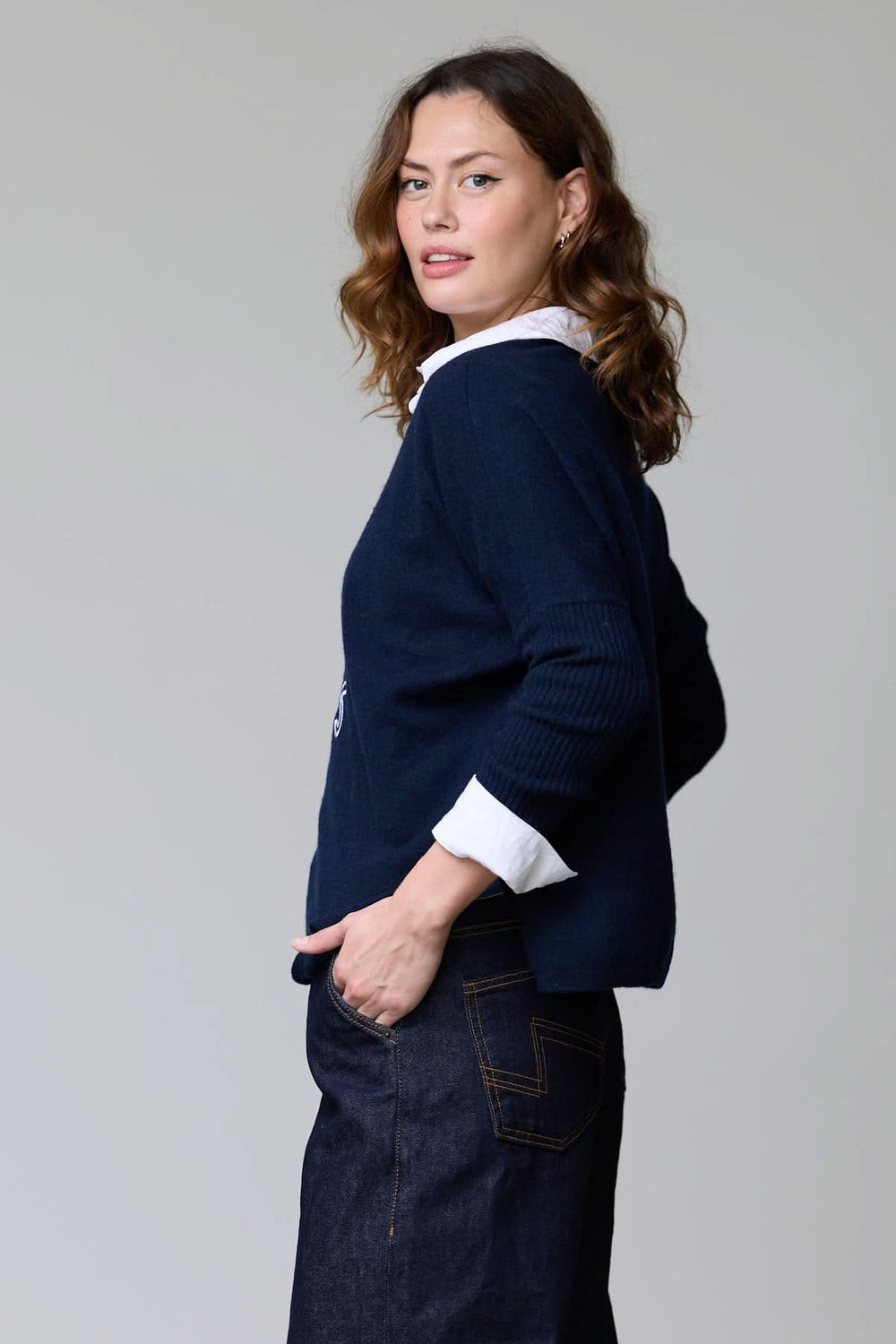 Alt Tag: Femme portant un chandail à col rond à message brodé "I ♥ Paris", avec coupe décontractée, sur fond gris neutre.