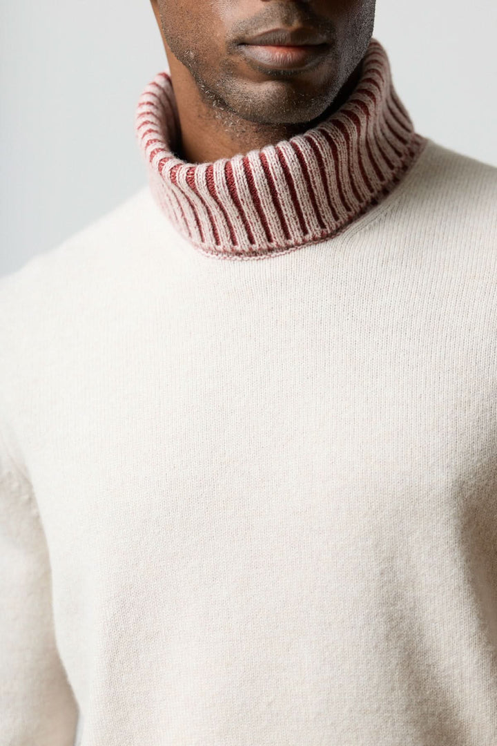 Chandail col roulé à côtes contrastées en maille douce avec bord-côtes rouge et blanc, idéal pour un style moderne.