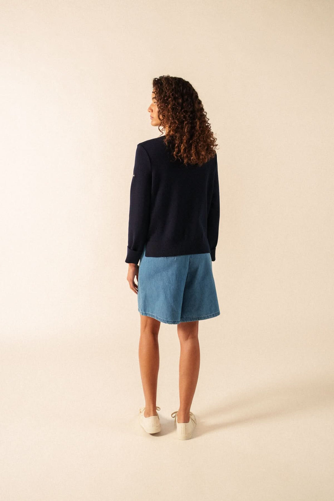 Femme portant le Chandail de tricot MARSEILLAN à rayures, coupe confortable et encolure arrondie, vu de dos dans un style décontracté.