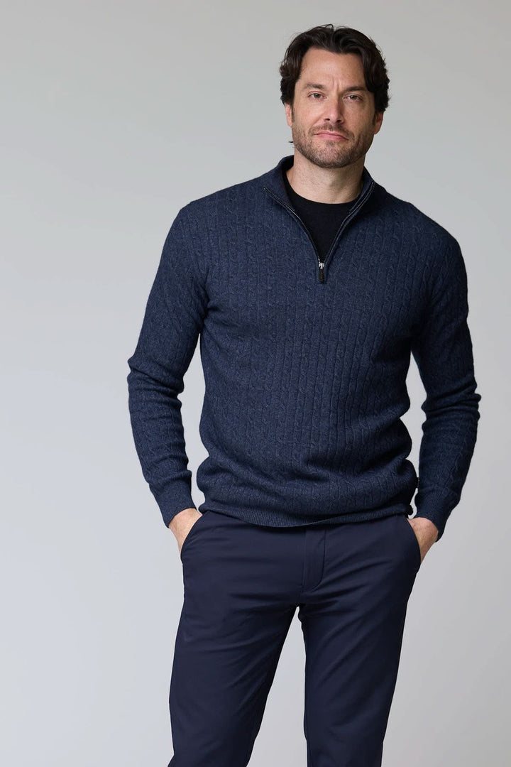 Chandail à demi-glissière torsadé en laine, tricot torsadé bleu marine, col montant, homme debout, mains dans les poches.
