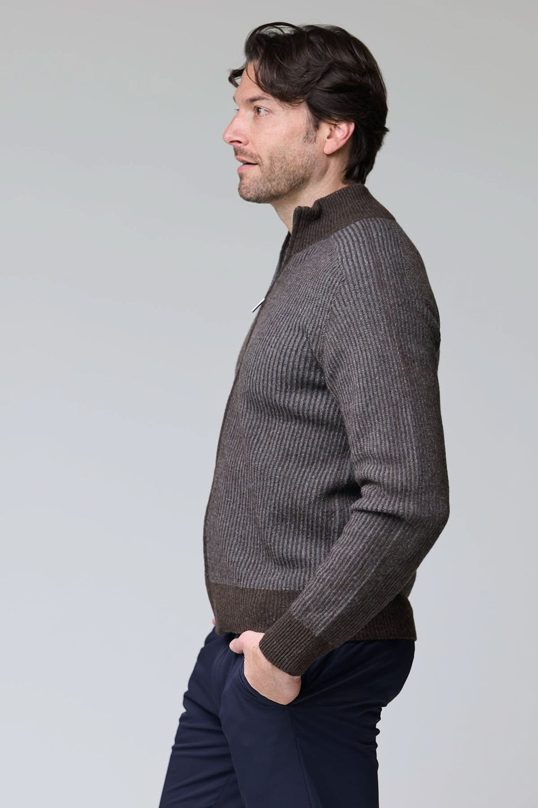 Un homme portant un chandail à demi-glissière torsadé en laine mérinos, élégant et confortable, parfait pour un style intemporel.