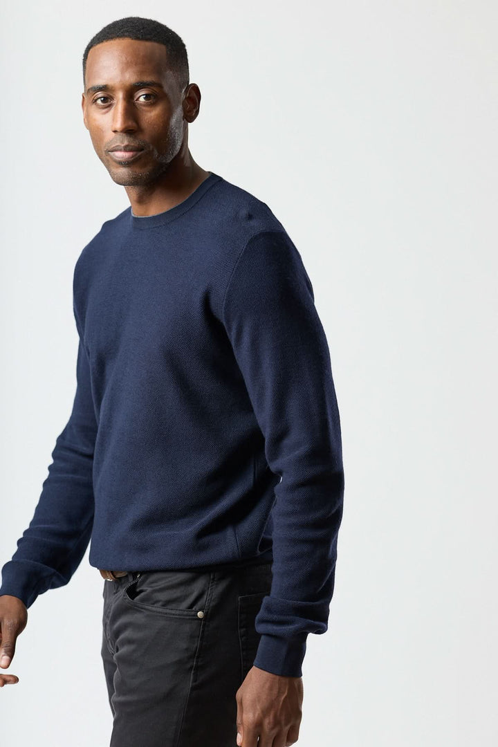 Homme portant un chandail en laine à col rond Corneliani, bleu, style élégant et confortable, parfait sous un veston pour un look raffiné.