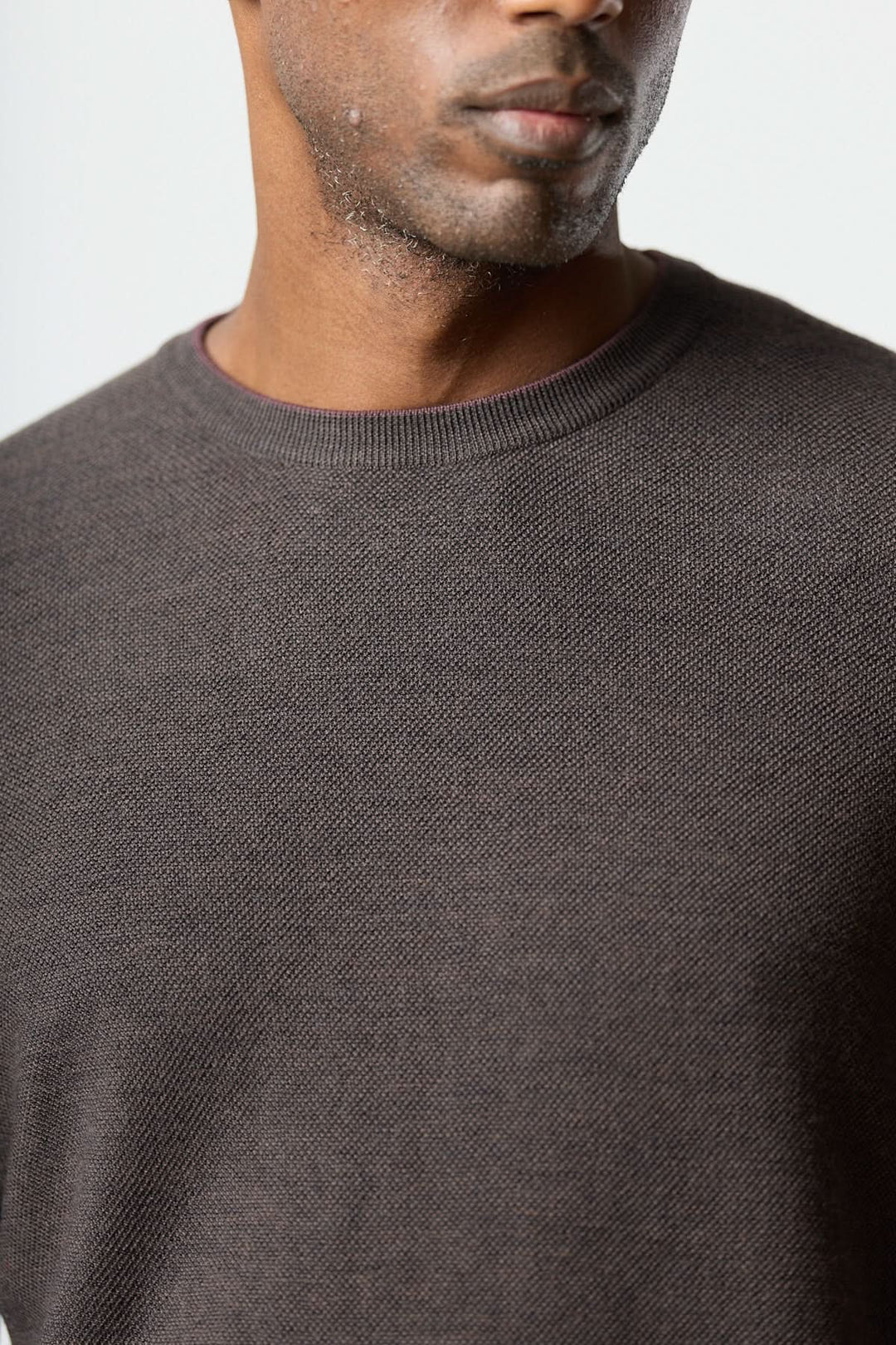 Homme portant un chandail en laine à col rond de couleur marron, en maille fine, adapté pour un style naturel et sophistiqué.