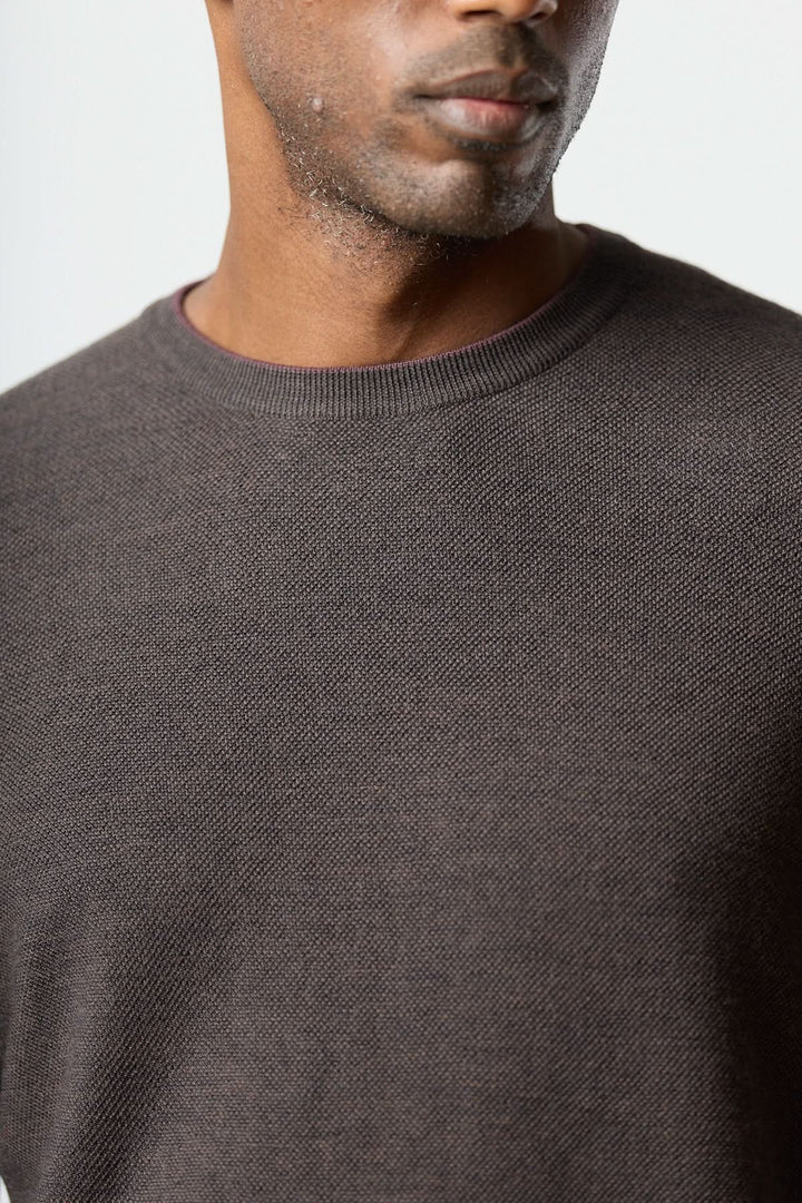 Homme portant un chandail en laine à col rond de couleur marron, en maille fine, adapté pour un style naturel et sophistiqué.
