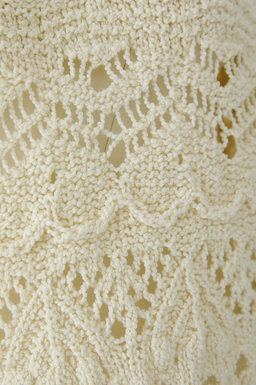 Chandail en maille ajourée avec motif texturé et détails féminins, idéal pour un style décontracté et confortable.