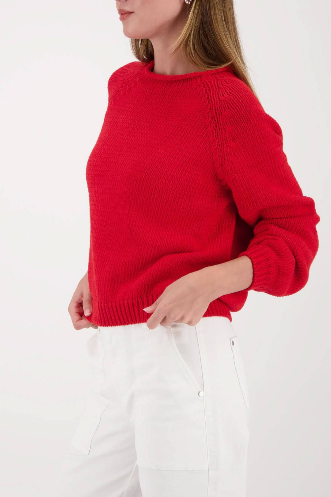 Femme portant un chandail en maille col rond rouge avec coupe droite légèrement écourtée, style décontracté et moderne.