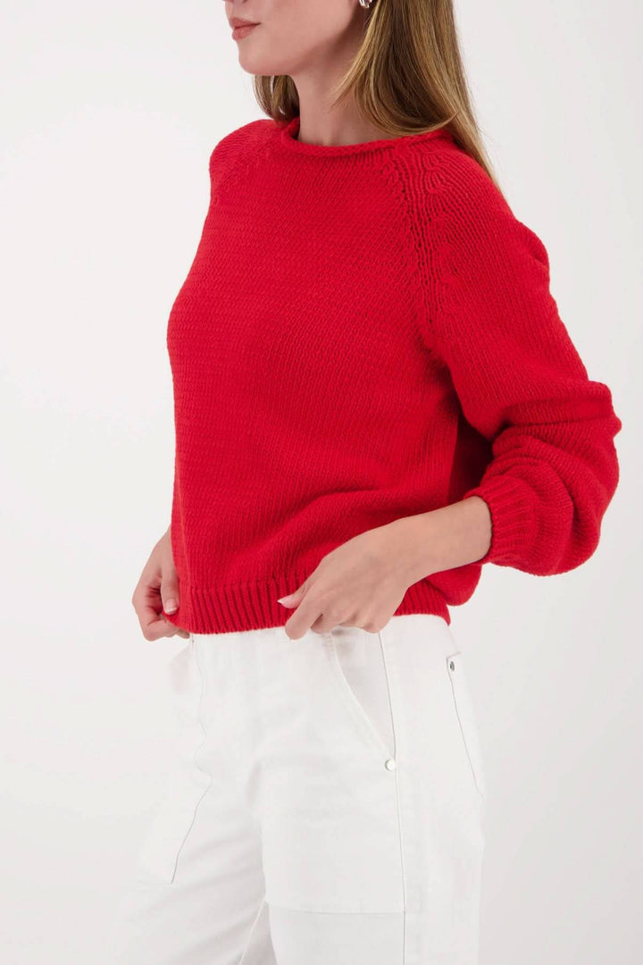 Femme portant un chandail en maille col rond rouge avec coupe droite légèrement écourtée, style décontracté et moderne.
