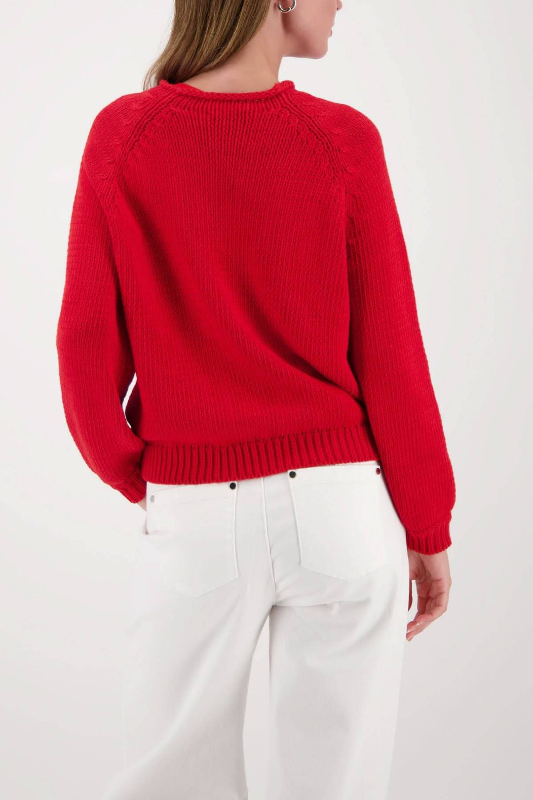 Femme portant un chandail en maille col rond rouge, coupe droite et écourtée, avec un pantalon blanc.