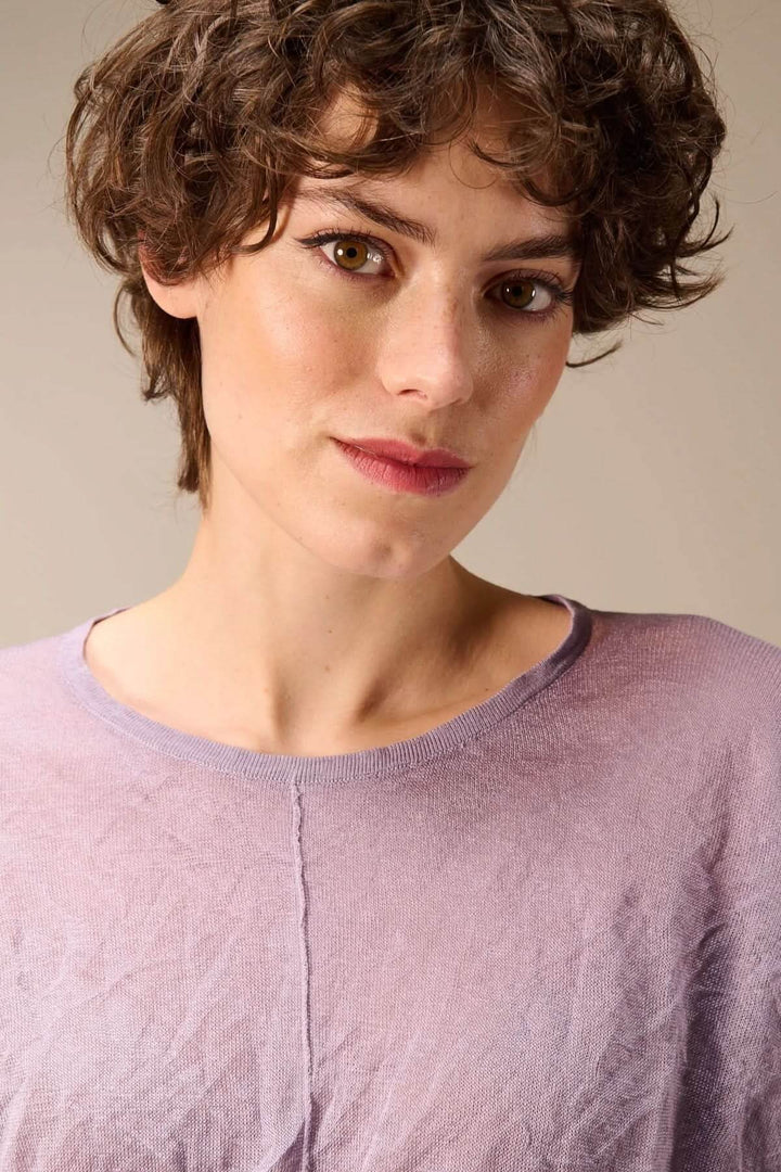 Femme portant un chandail en maille fine léger à encolure ronde avec texture froissée, style moderne et décontracté.