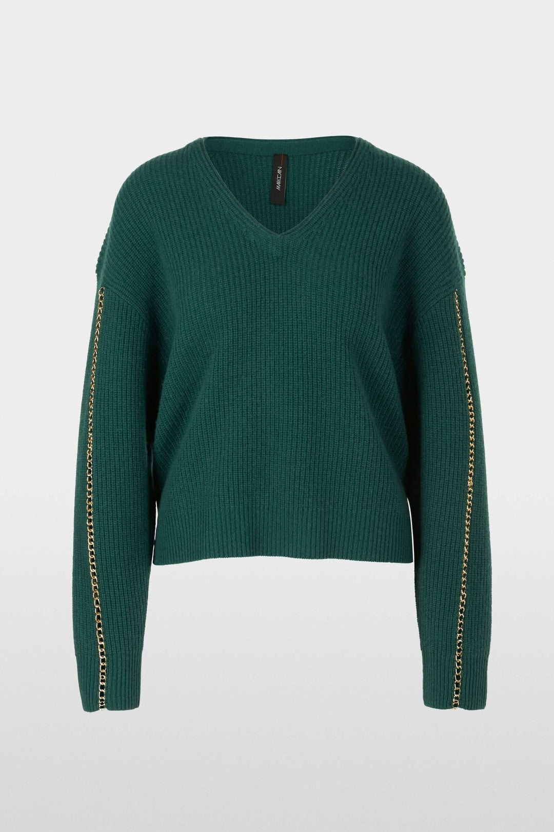 Pull en mailles vert émeraude avec col en V et chaîne en métal sur les manches, coupe large.