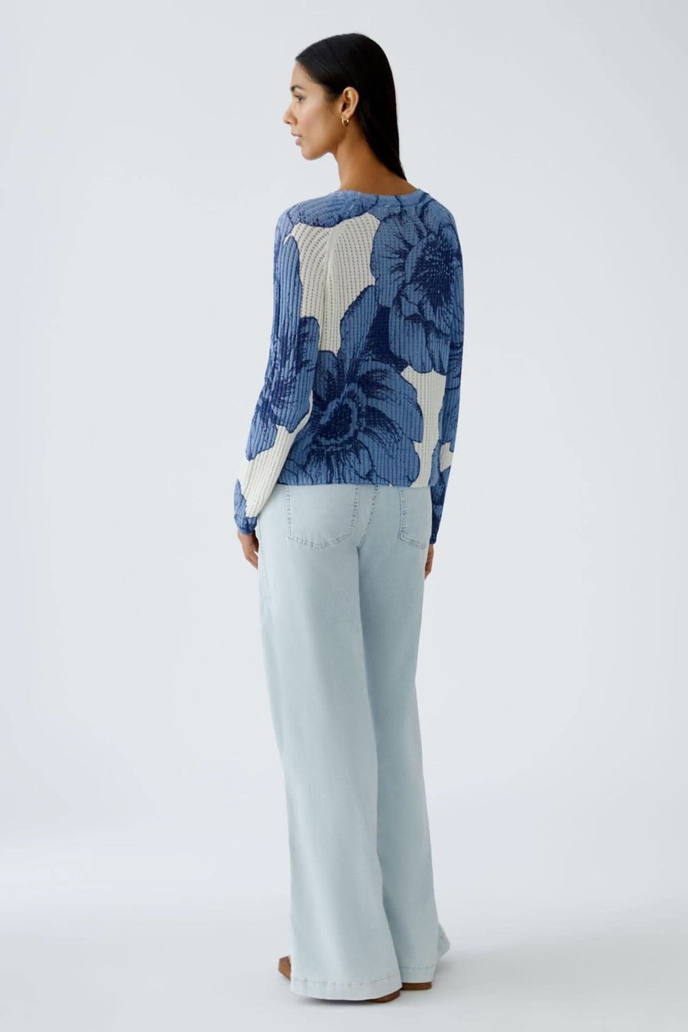 Chandail en tricot côtelé à motif floral, coupe décontractée avec manches longues, porté avec un pantalon clair.