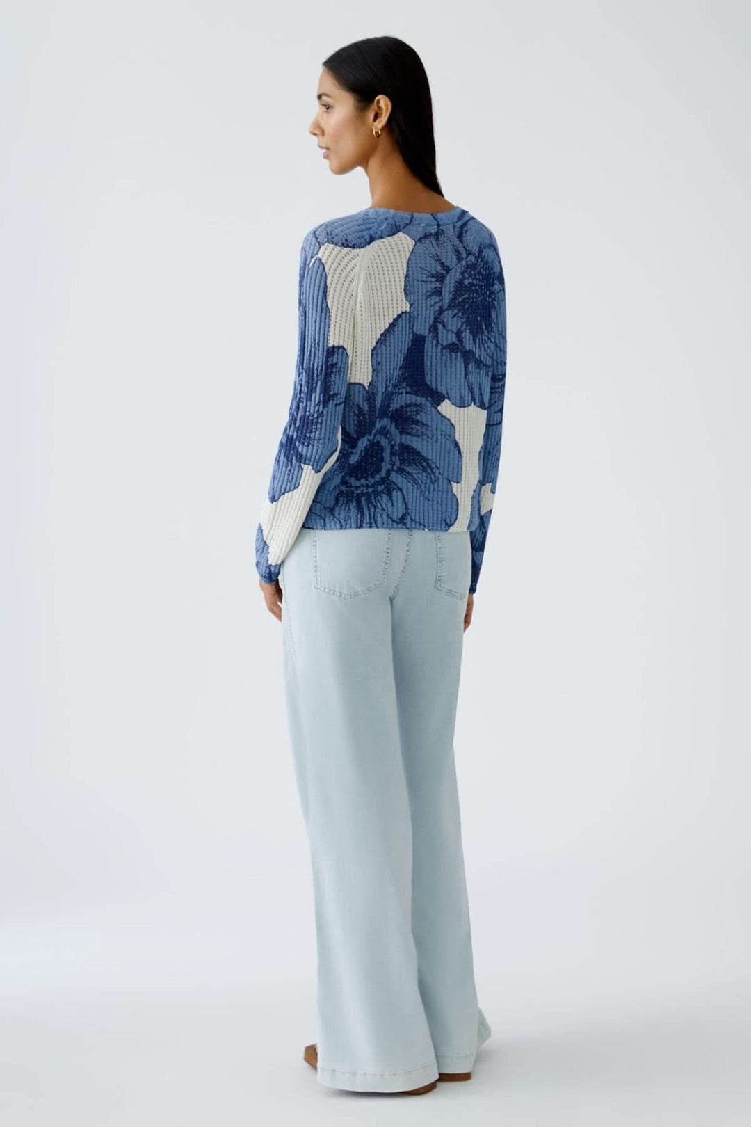 Chandail en tricot côtelé à motif floral, coupe décontractée avec manches longues, porté avec un pantalon clair.