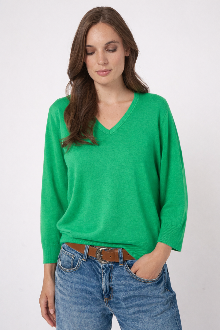 Chandail en tricot à col en V vert porté par un modèle, coupe droite et manches longues, look décontracté.