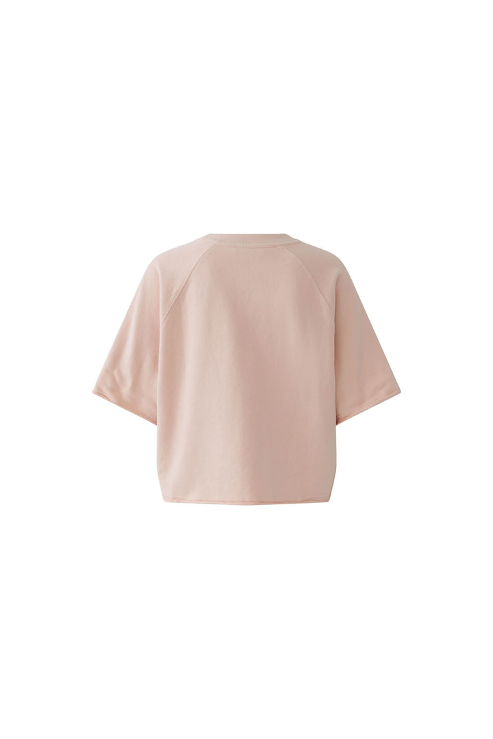 Chandail imprimé graphique à manches courtes, coupe ample et légèrement raccourcie, esprit rétro et moderne, couleur rose, dos visible.
