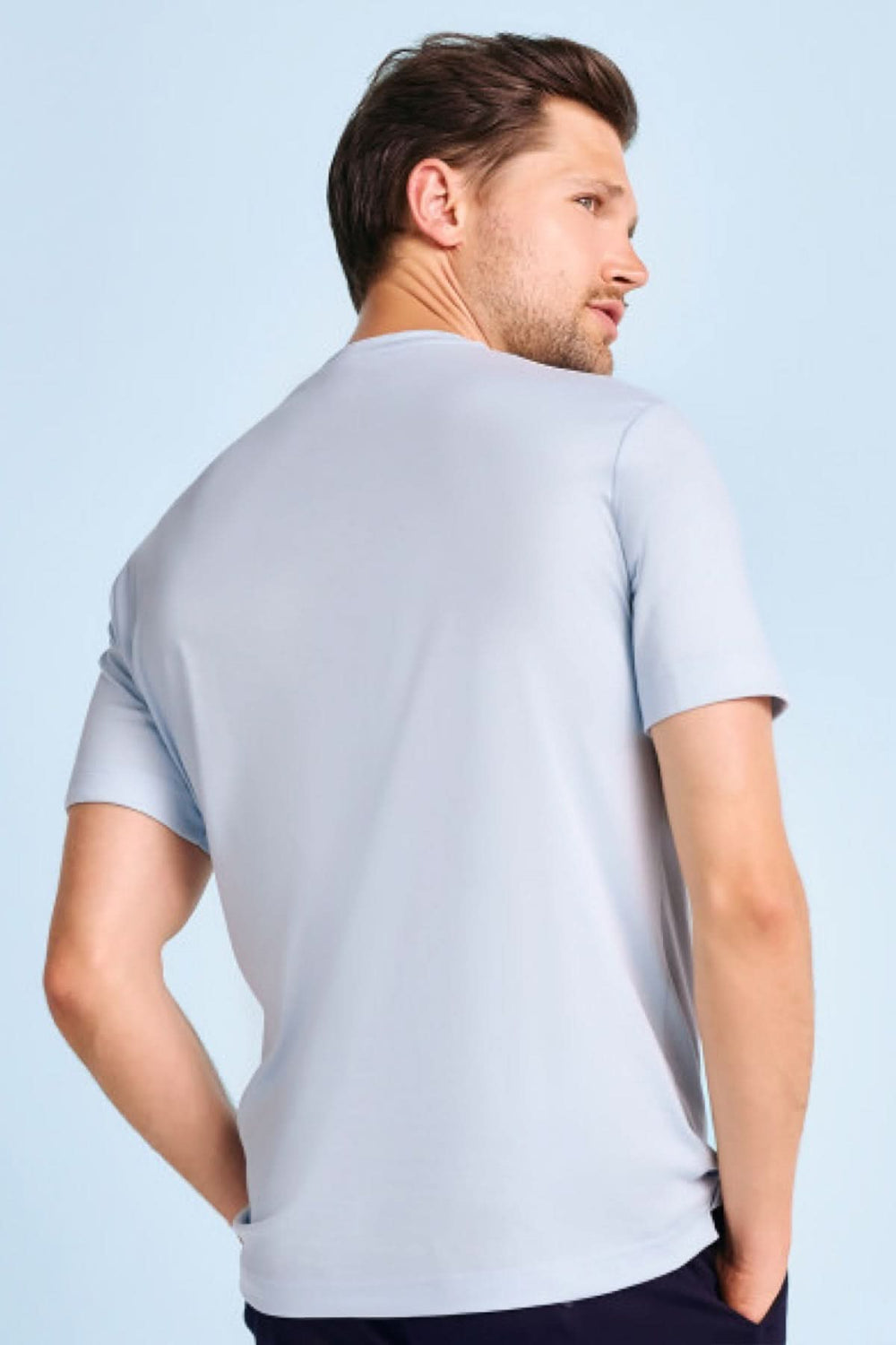 Homme portant un Chandail à manches courtes essentiel couleur bleu clair, col rond, ajusté pour un look moderne et élégant.