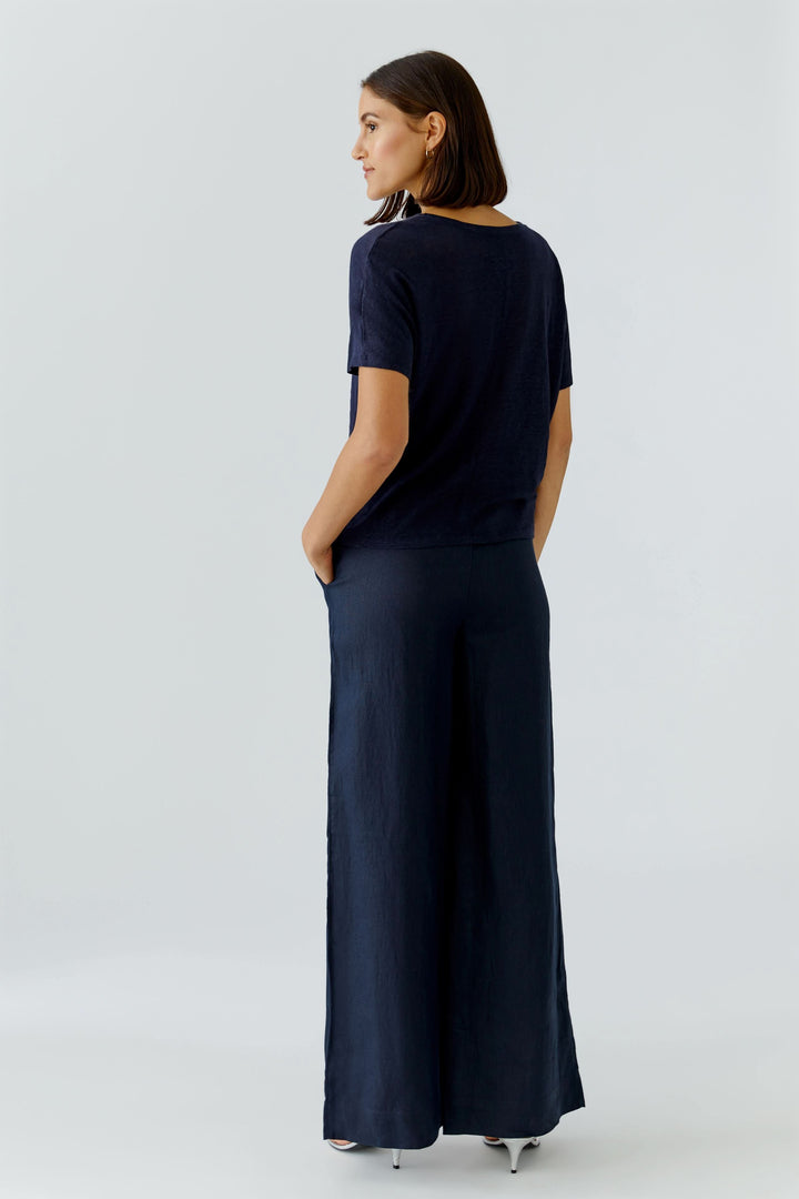 Chandail à manches courtes fluide porté par une femme de dos, coupe ample et confortable, style décontracté raffiné.