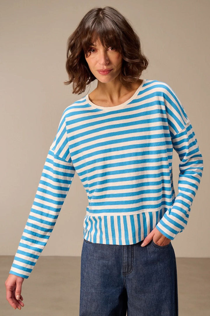 Femme portant un chandail à manches longues rayé coupe décontractée, confort et style pour toutes les occasions.