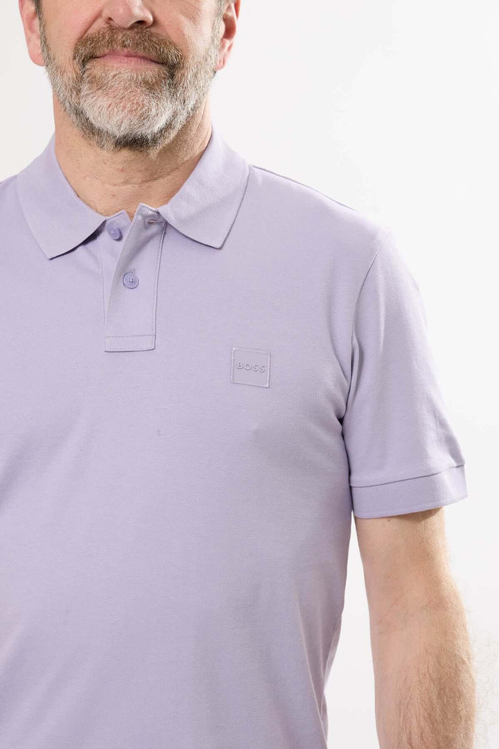 Homme portant un polo classique lilas BOSS avec logo discret sur la poitrine.
