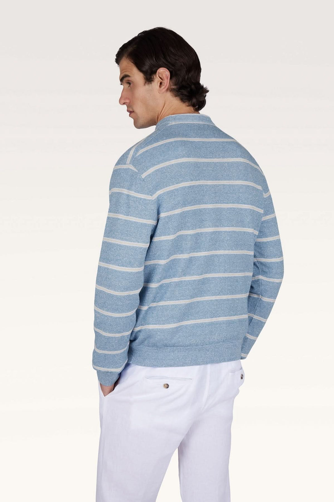 Homme portant le chandail rayé en lin et coton Urukai, inspiré du style Riviera, avec une coupe régulière. Look estival moderne.