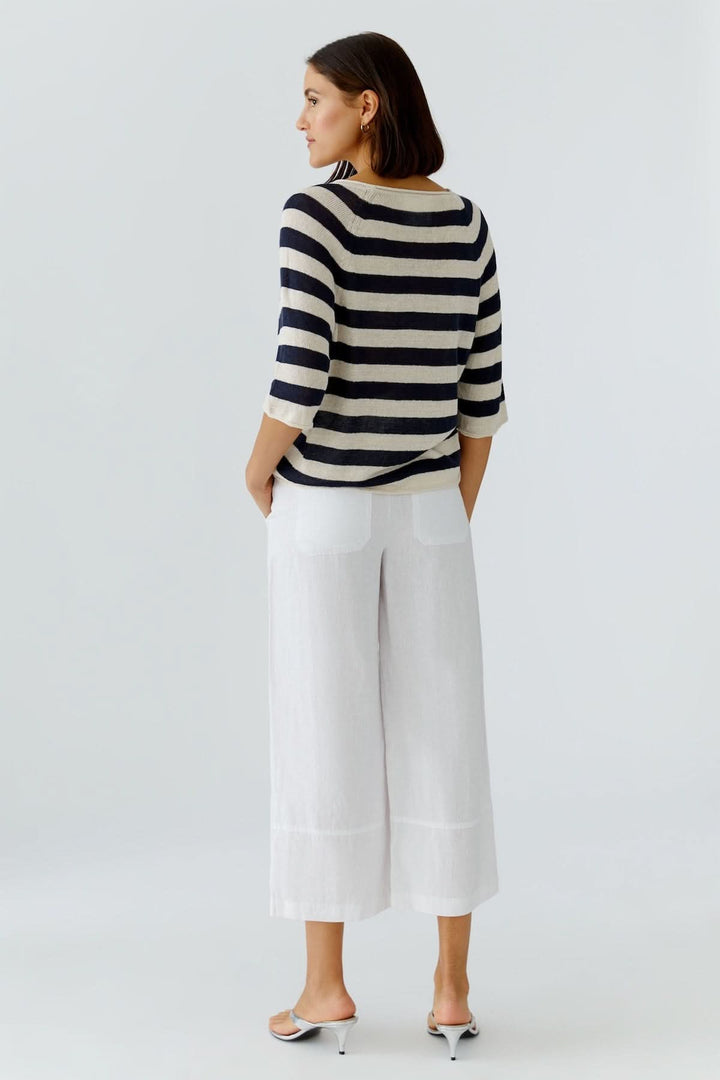 Chandail à rayures texturées manches trois-quarts porté de dos avec pantalon blanc, style décontracté et élégant.