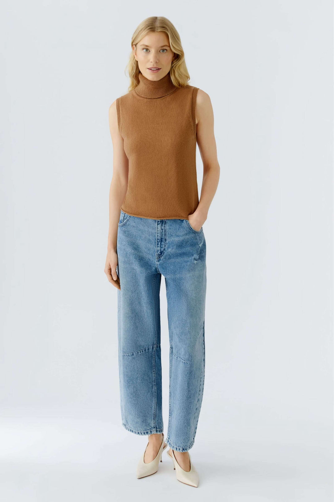 Chandail sans manches à col roulé, dos ajouré, pour un look stylé et minimaliste avec une touche féminine. Décris moi le produit en français.