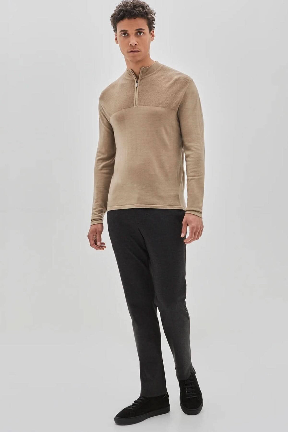 Homme portant un chandail zippé Newbury en laine mérinos, offrant confort et élégance moderne.