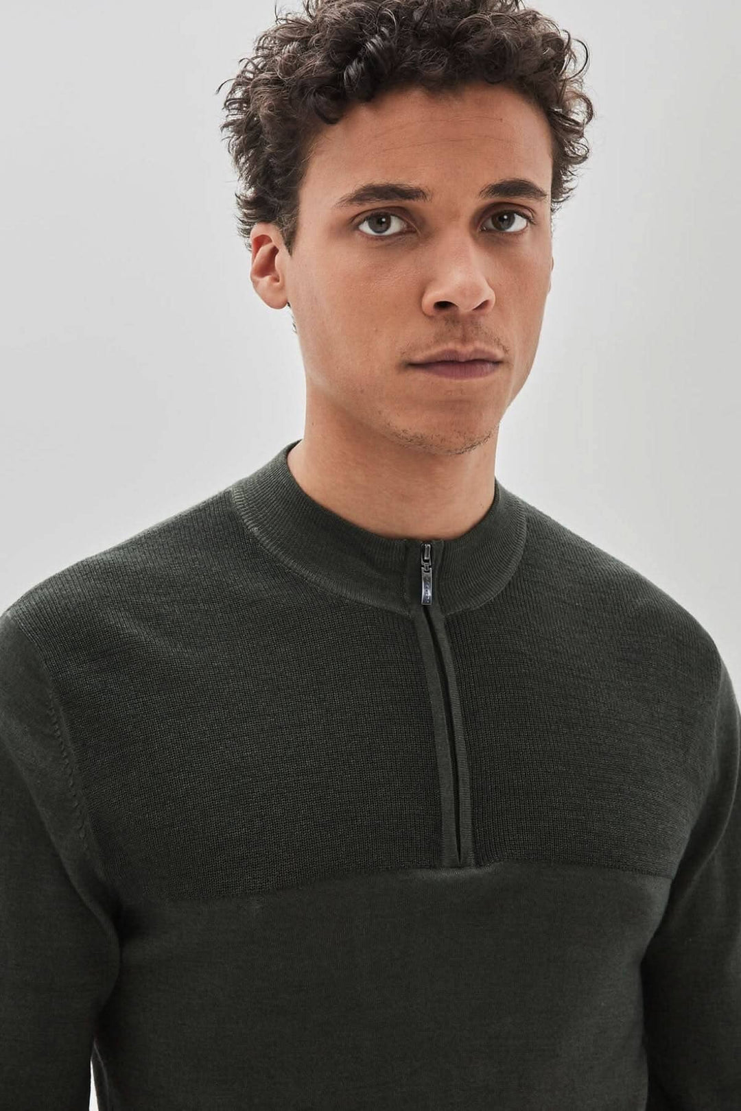 Homme portant un chandail zippé Newbury en laine mérinos extrafine, couleur vert foncé.