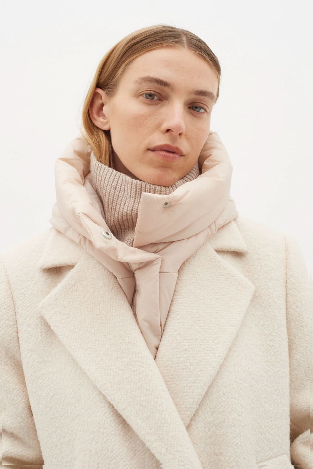 Femme portant une capuche matelassée avec un manteau élégant pour une protection du froid.