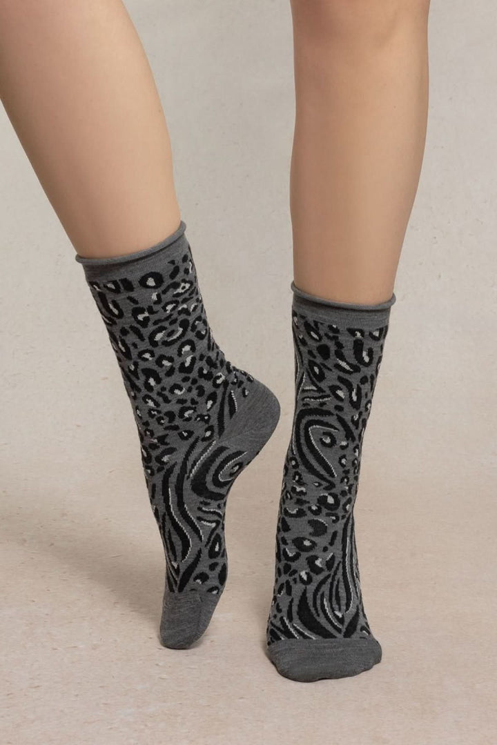 Chaussettes en maille à motif animalier stylisé noir-gris sur fond beige, mi-mollet, confortables et élégantes pour style audacieux.