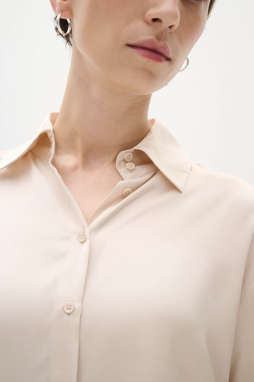 Chemise Pauline satinée, ample et chic, avec col de chemise et boutons sur le devant, portée par un modèle.