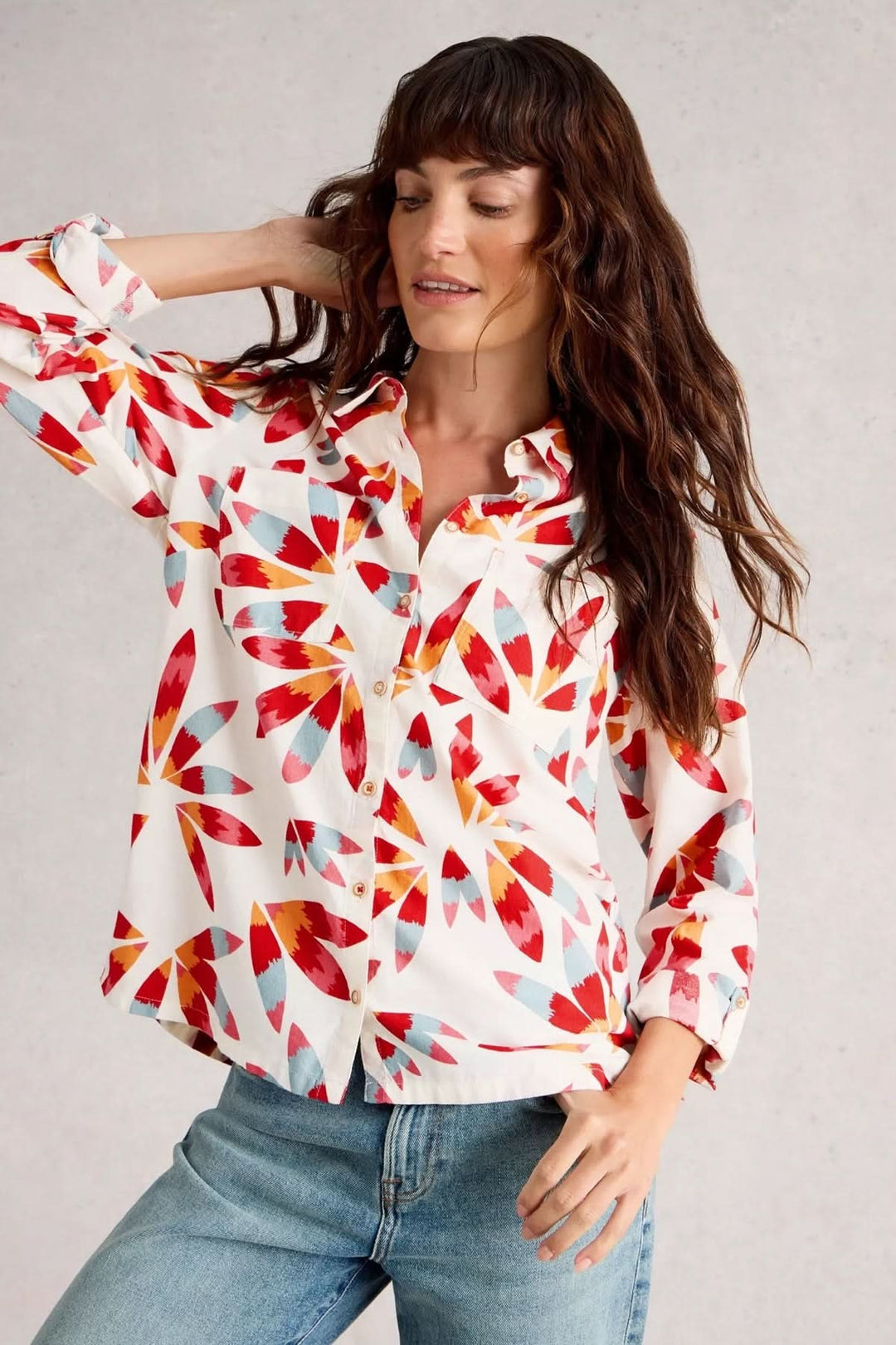 Femme portant la Chemise Sophie avec un imprimé coloré, manches longues et col classique, idéale pour un look stylé et énergique.