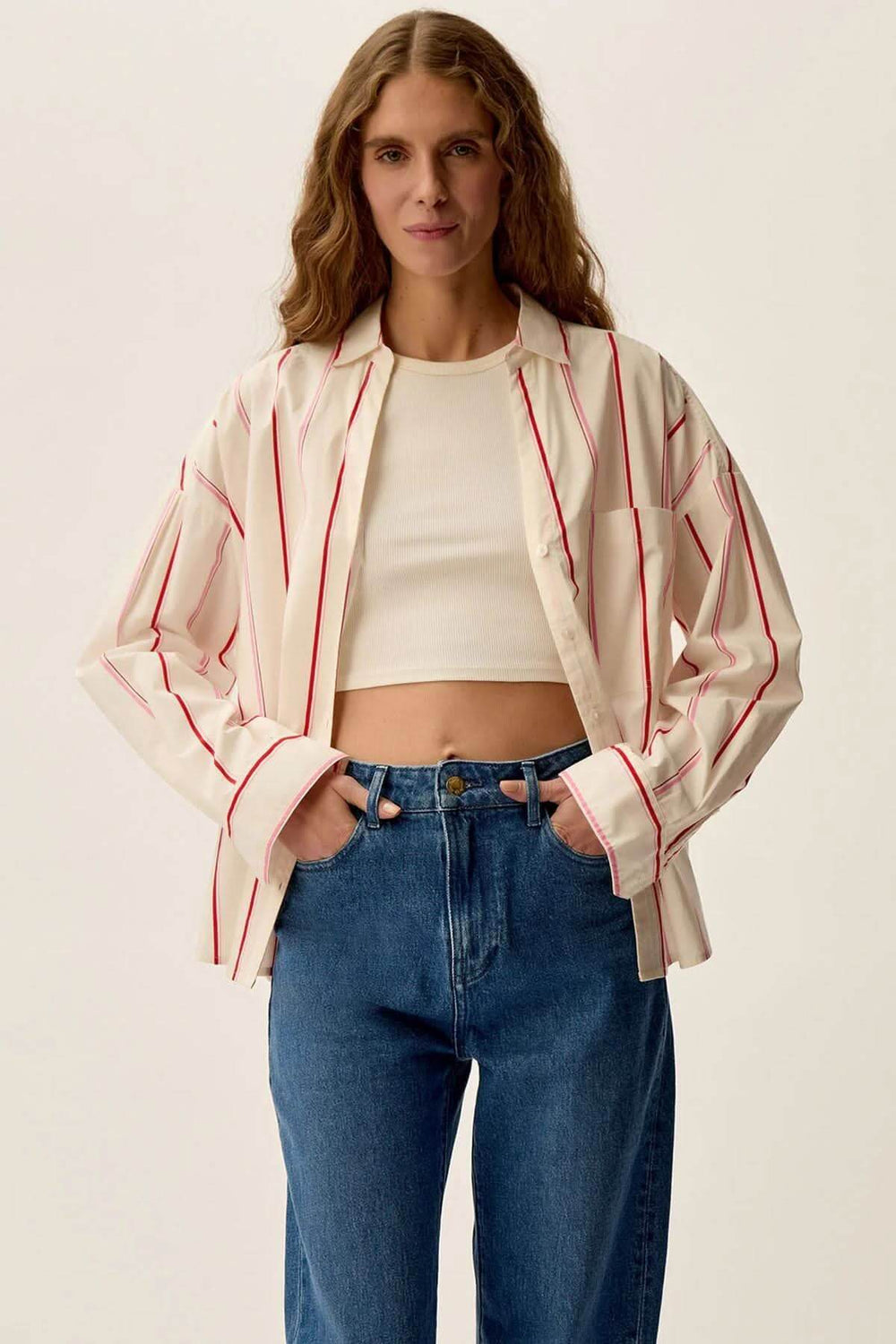 Chemise Ulysse blanche à rayures rouges, manches longues, portée avec un jean classique, look chic et intemporel.