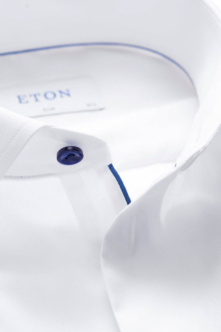 Chemise blanche avec boutons marines, en twill infroissable, idéale pour une tenue d’affaires élégante.