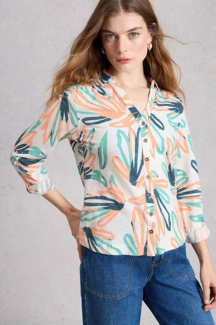 Femme portant la chemise boutonnée col en V manches trois-quarts Annie avec motif floral coloré, tenue décontractée élégante.