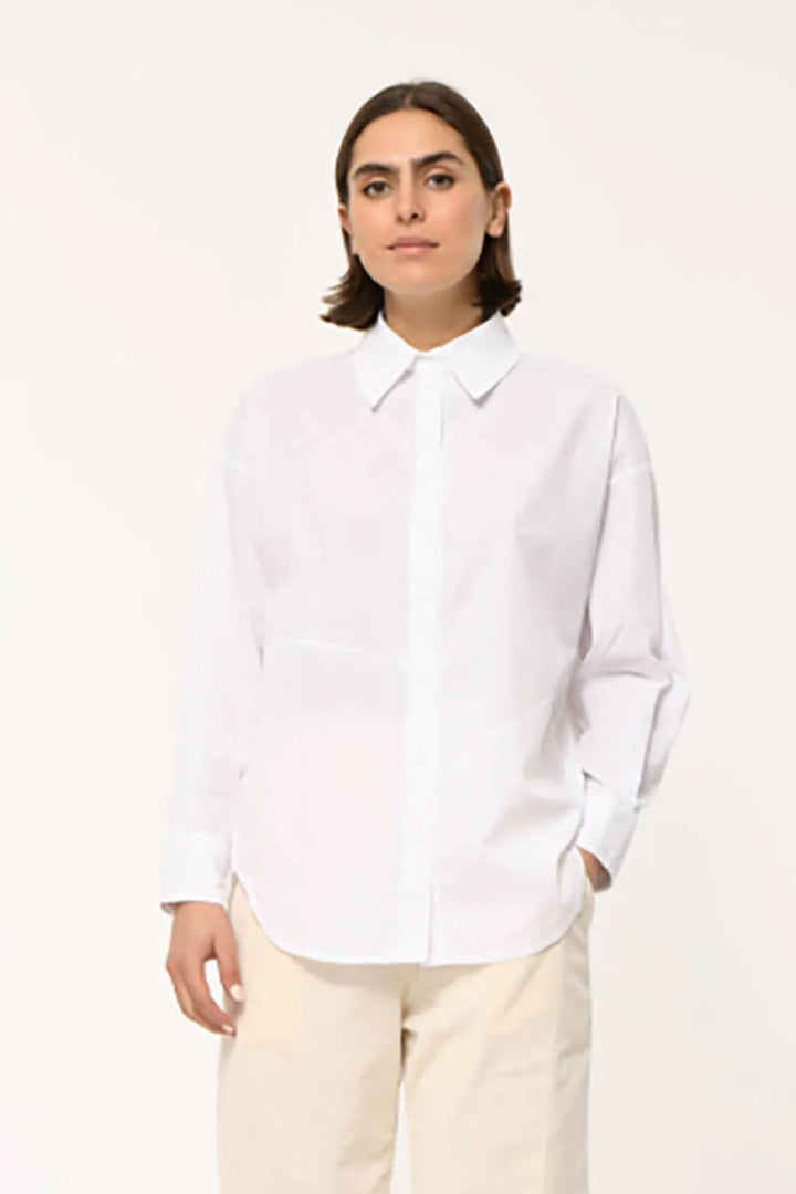Femme portant une chemise classique à coupe droite avec col pointu, idéale pour un style moderne et confortable.