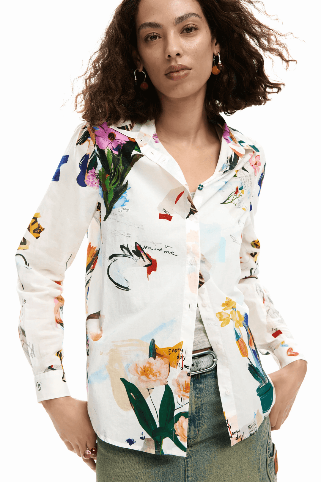 Femme portant une chemise collage fleurs avec imprimé artistique, coupe droite, col classique, manches longues, style moderne et fluide.