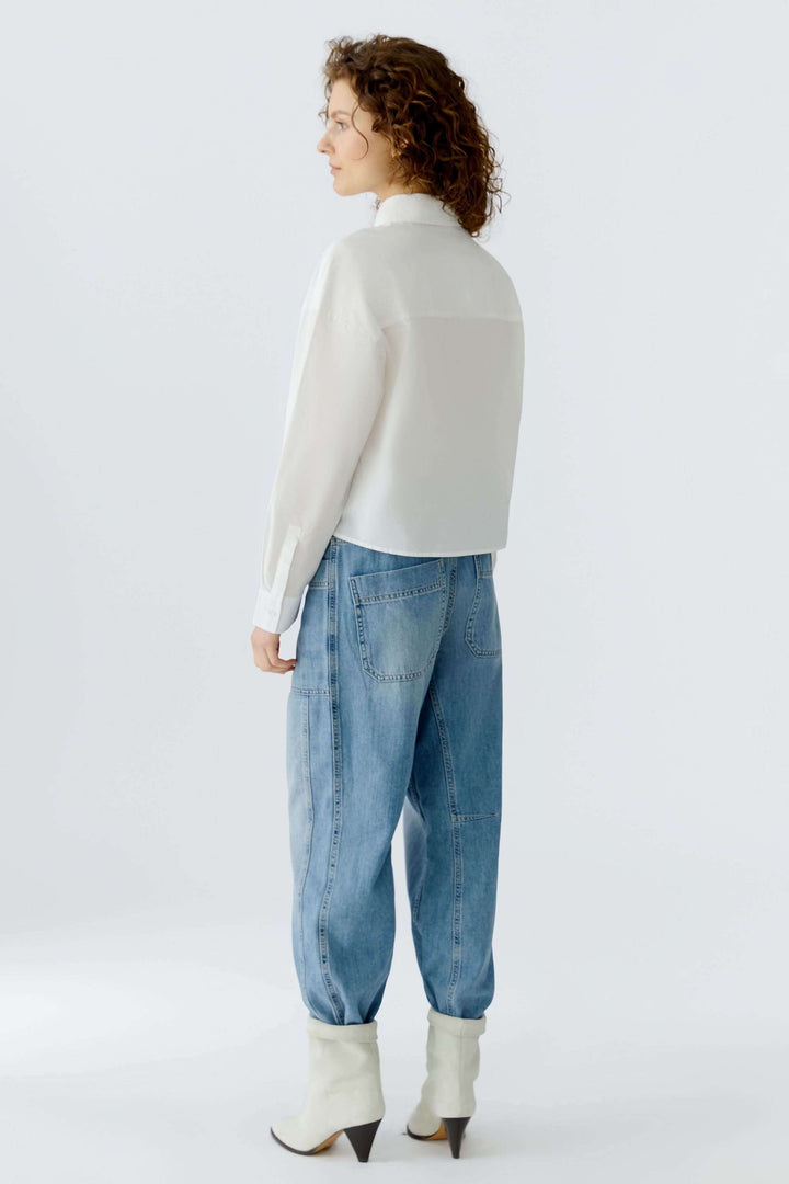 Chemise coupe moderne avec broderies florales, vue arrière sur mannequin, style décontracté et élégant.