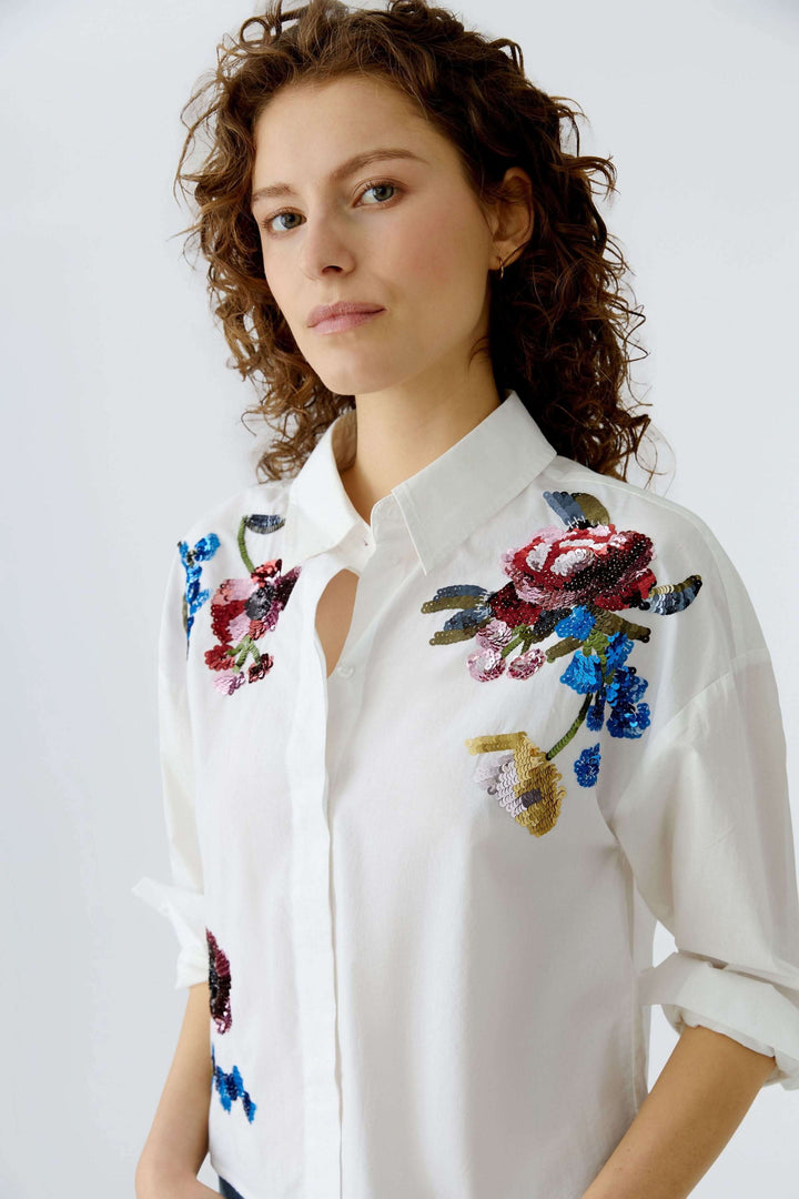 Chemise coupe moderne avec broderies florales, élégante et féminine, idéale pour un look raffiné.