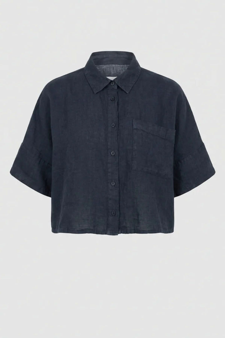 Chemise courte en lin à coupe ample avec col classique et poche plaquée, vue de face.