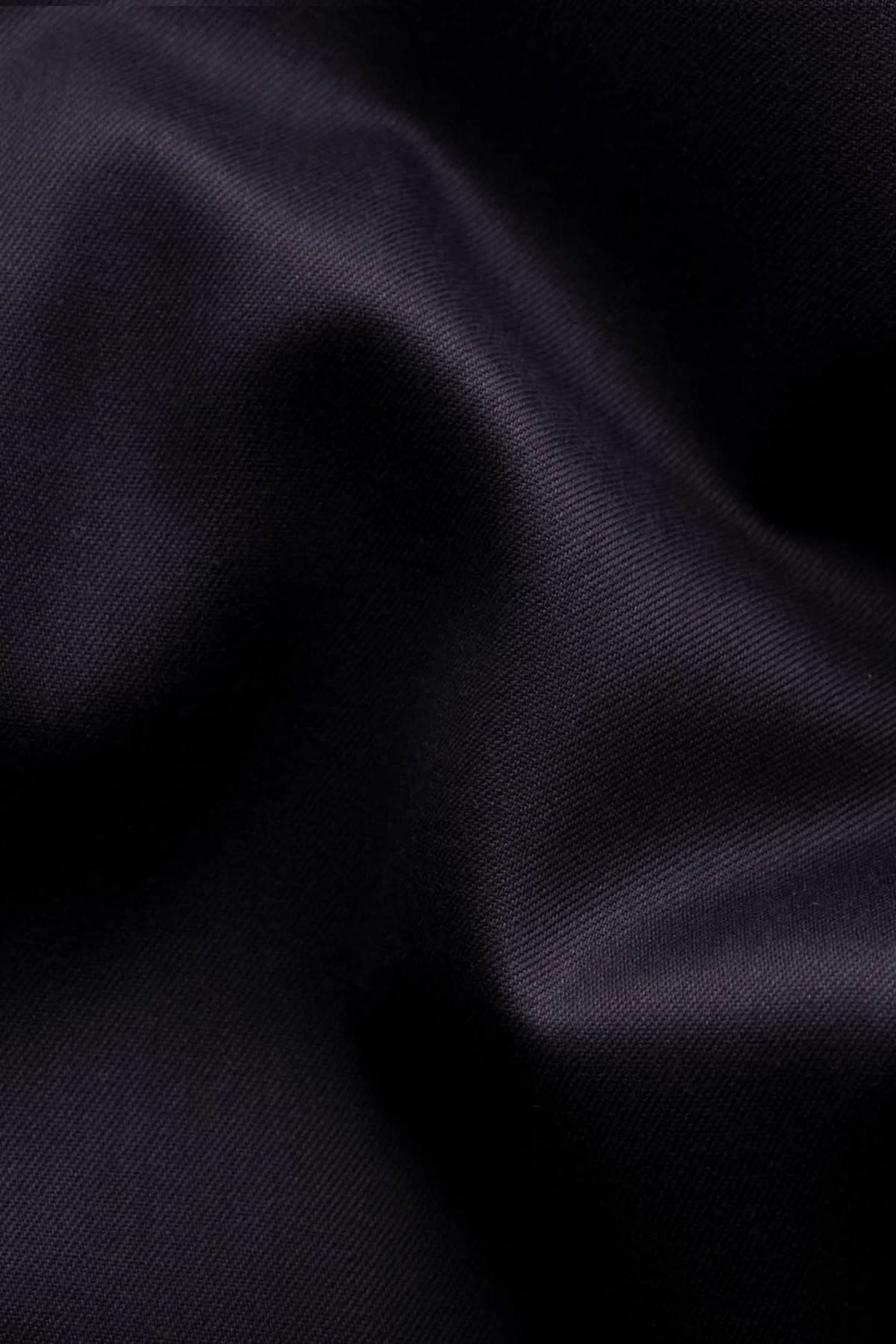 Texture de coton twill sombre pour chemise en coton twill avec détails cachemire, soulignant la qualité et l'élégance du tissu.