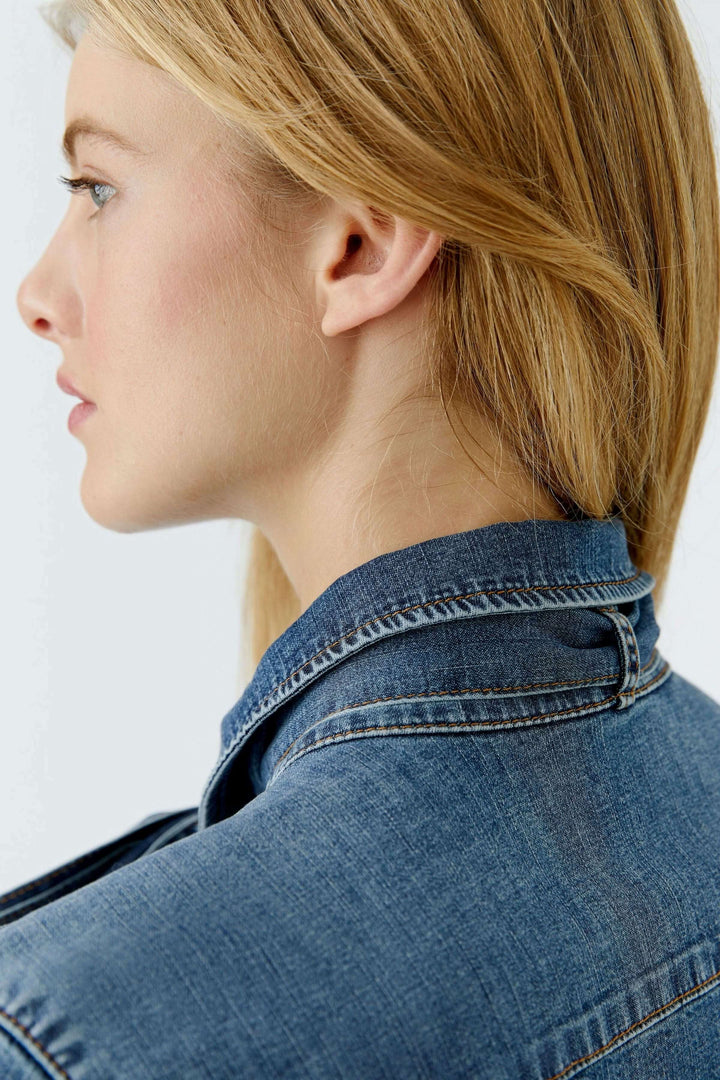 Vue latérale d'une chemise en denim avec nœud amovible, mettant en valeur le col lavallière et la texture du denim.