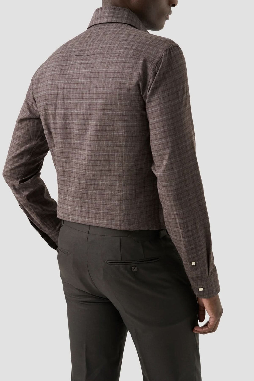 Chemise en flanelle à carreaux vue de dos, ajustée et élégante, portée avec un pantalon noir.
