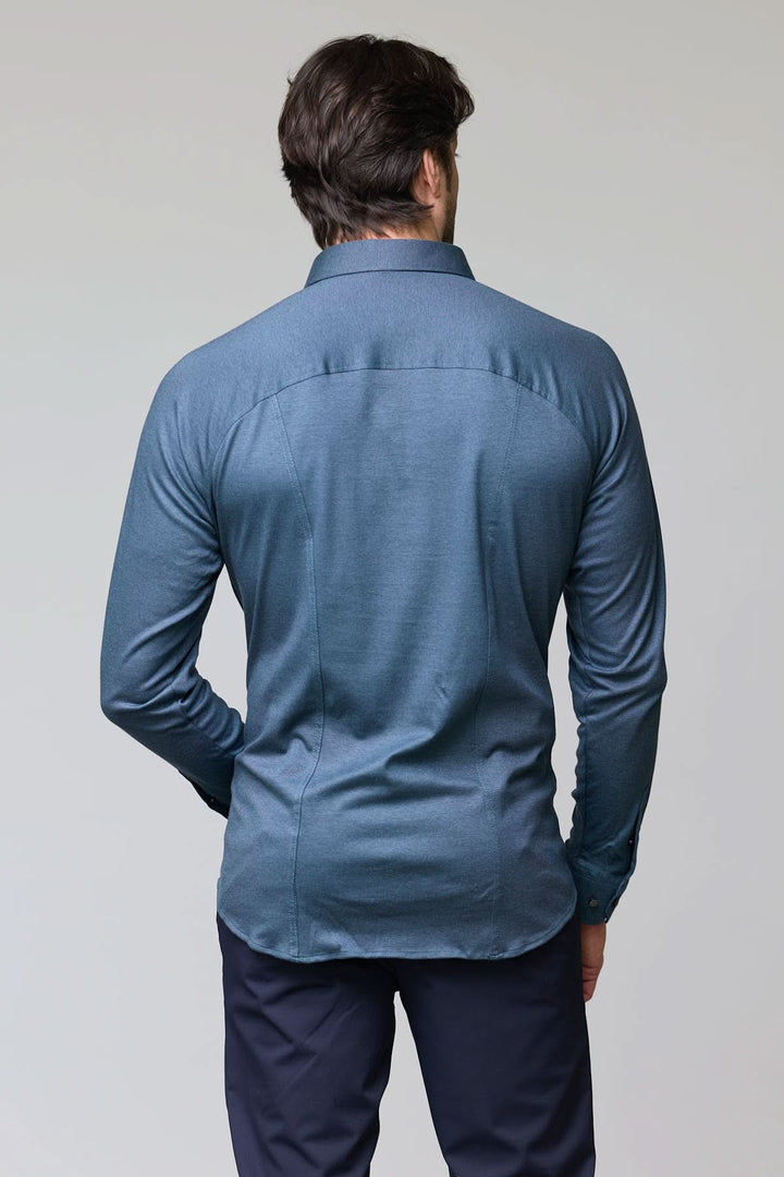 Homme portant une chemise en jersey extensible bleue, manches longues, vue de dos, coupe ajustée et col structuré.