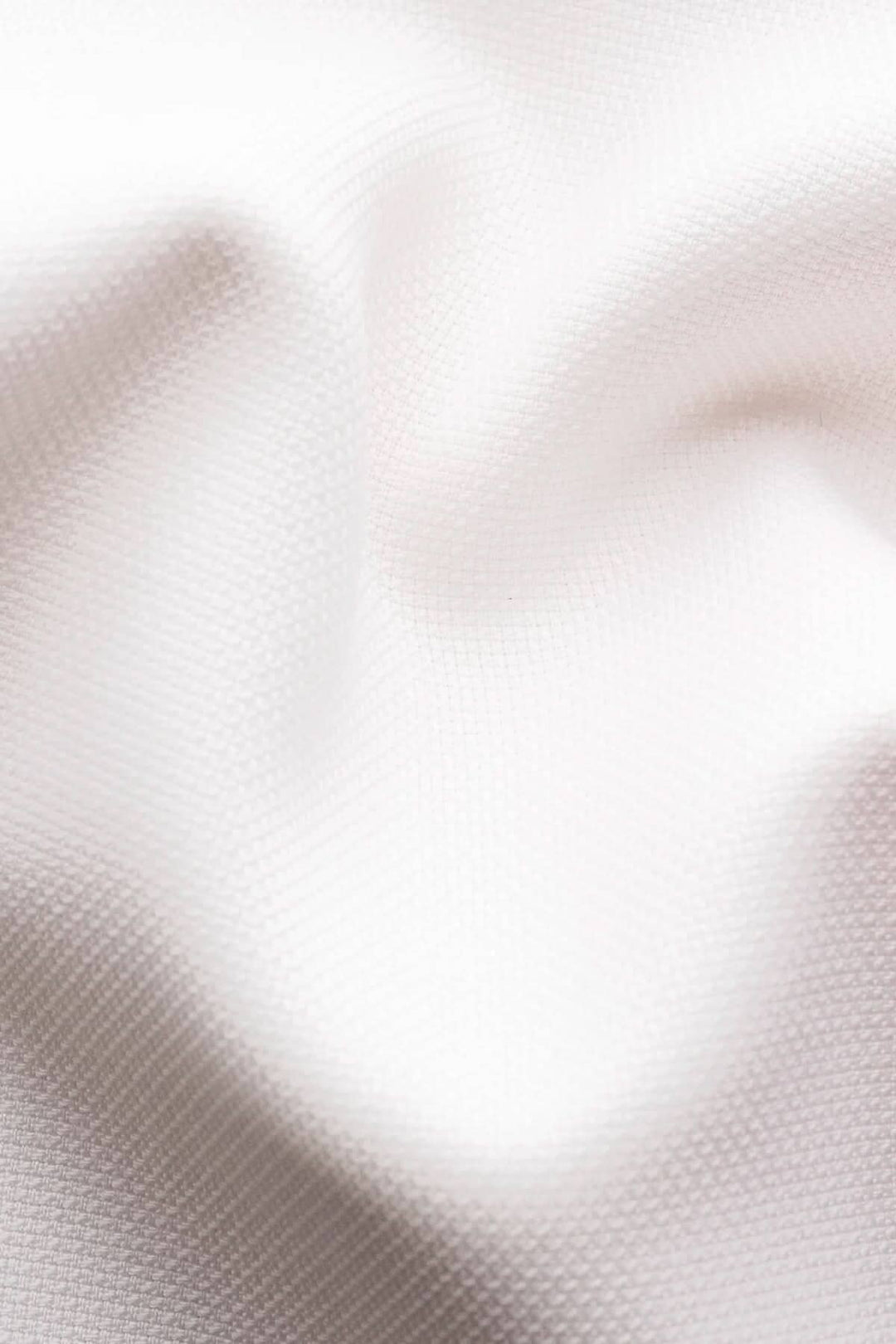 Tissu blanc texturé en laine, parfait pour une chemise en été.