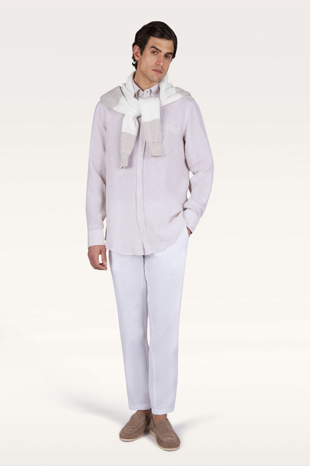 Homme portant une chemise en lin Soffio avec pantalon blanc et pull noué sur les épaules